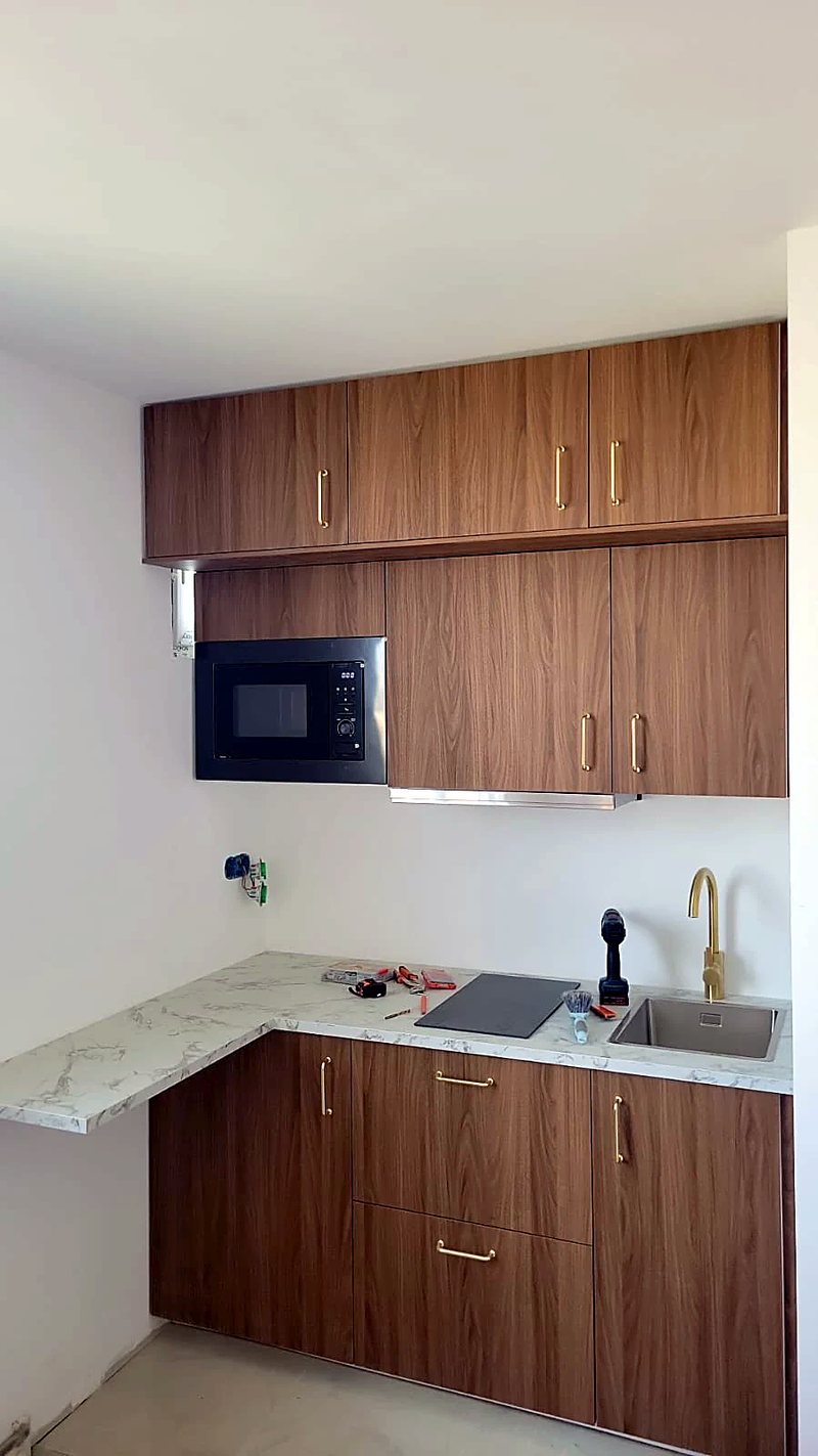 Kitchenette noyer, poignées laiton, plan marbre